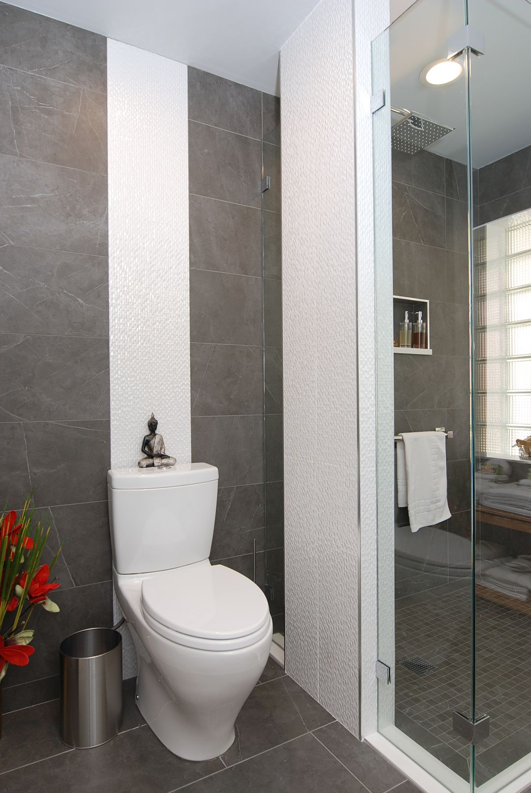 North Shore guest bathroom with floor-to-ceiling gray tile, white accent columns, and glass shower – Kelly Thayer Design