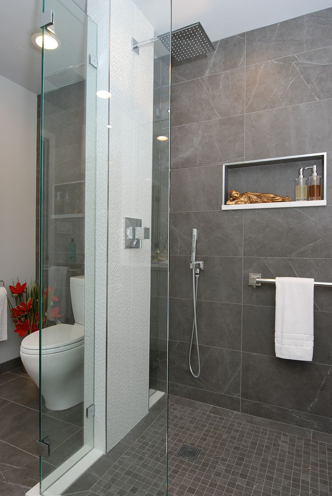 North Shore curbless shower with gray stone tile, recessed shampoo niche, and ceiling rain head – Kelly Thayer Design
