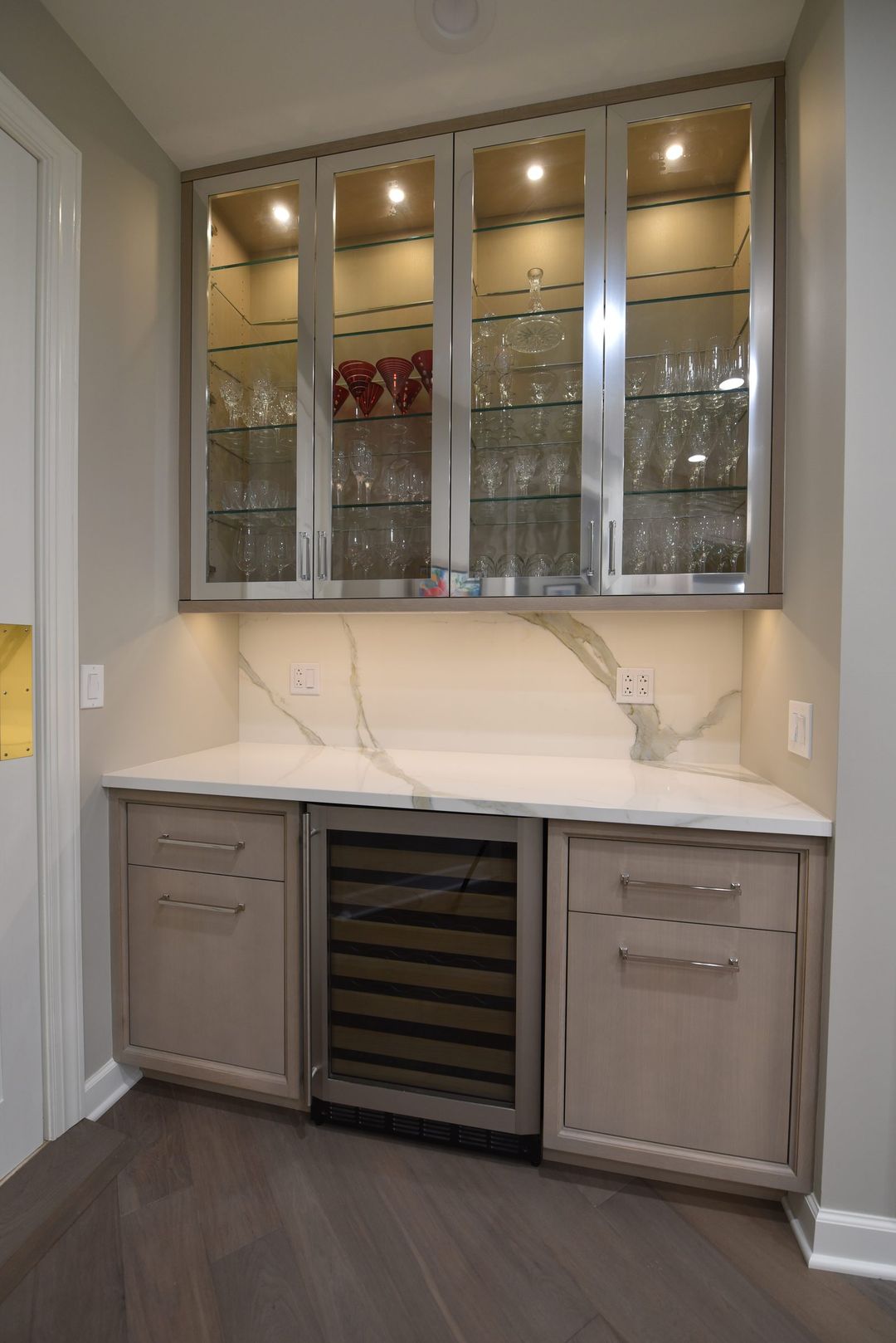 Northbrook bar with metal and glass upper cabinet fronts, Calacatta quartz countertop and backsplash, and built-in wine cooler - Kelly Thayer Design