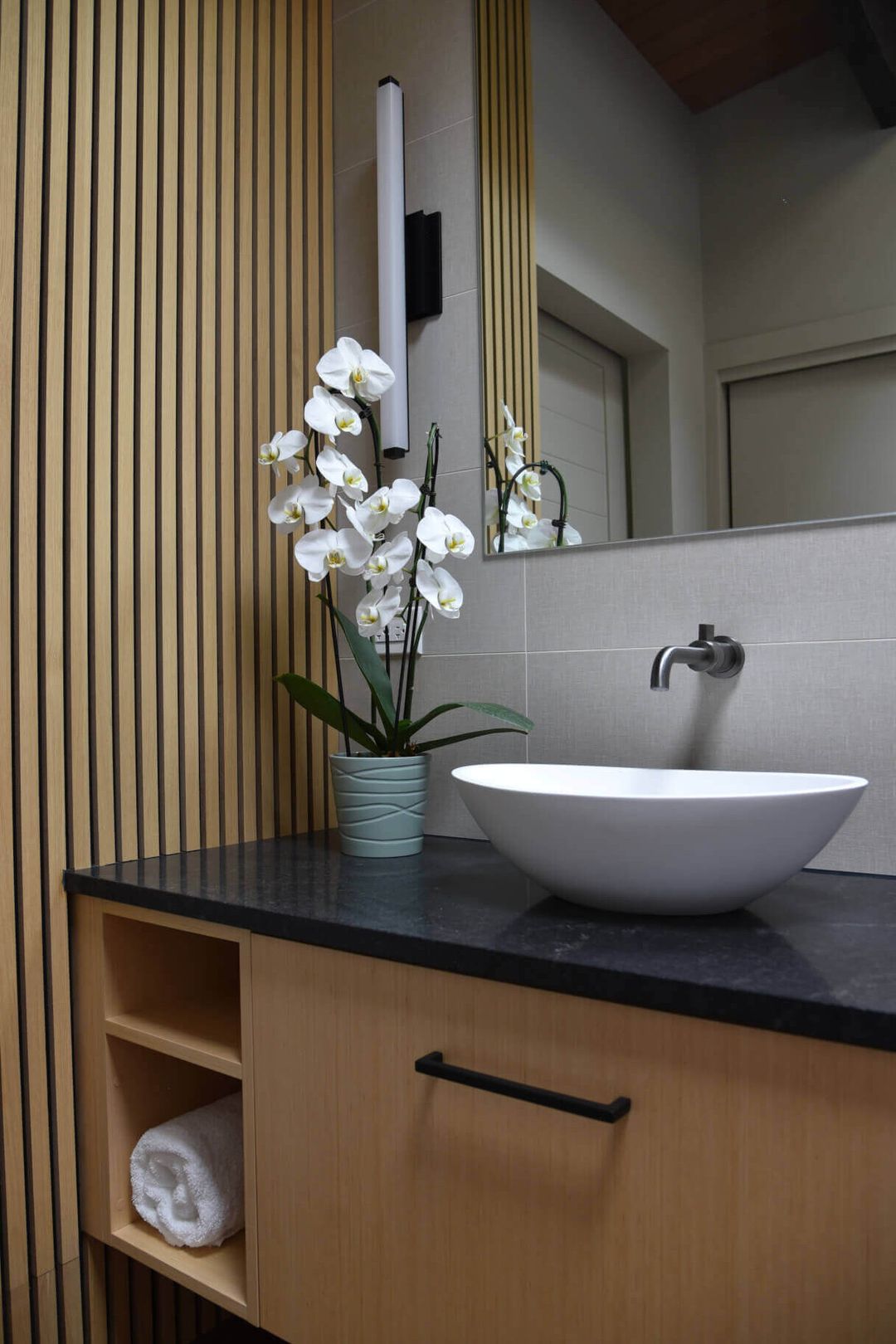 Riverwoods bathroom with wood floating vanity, vessel sink, and vertical wood slat accent wall – Kelly Thayer Design