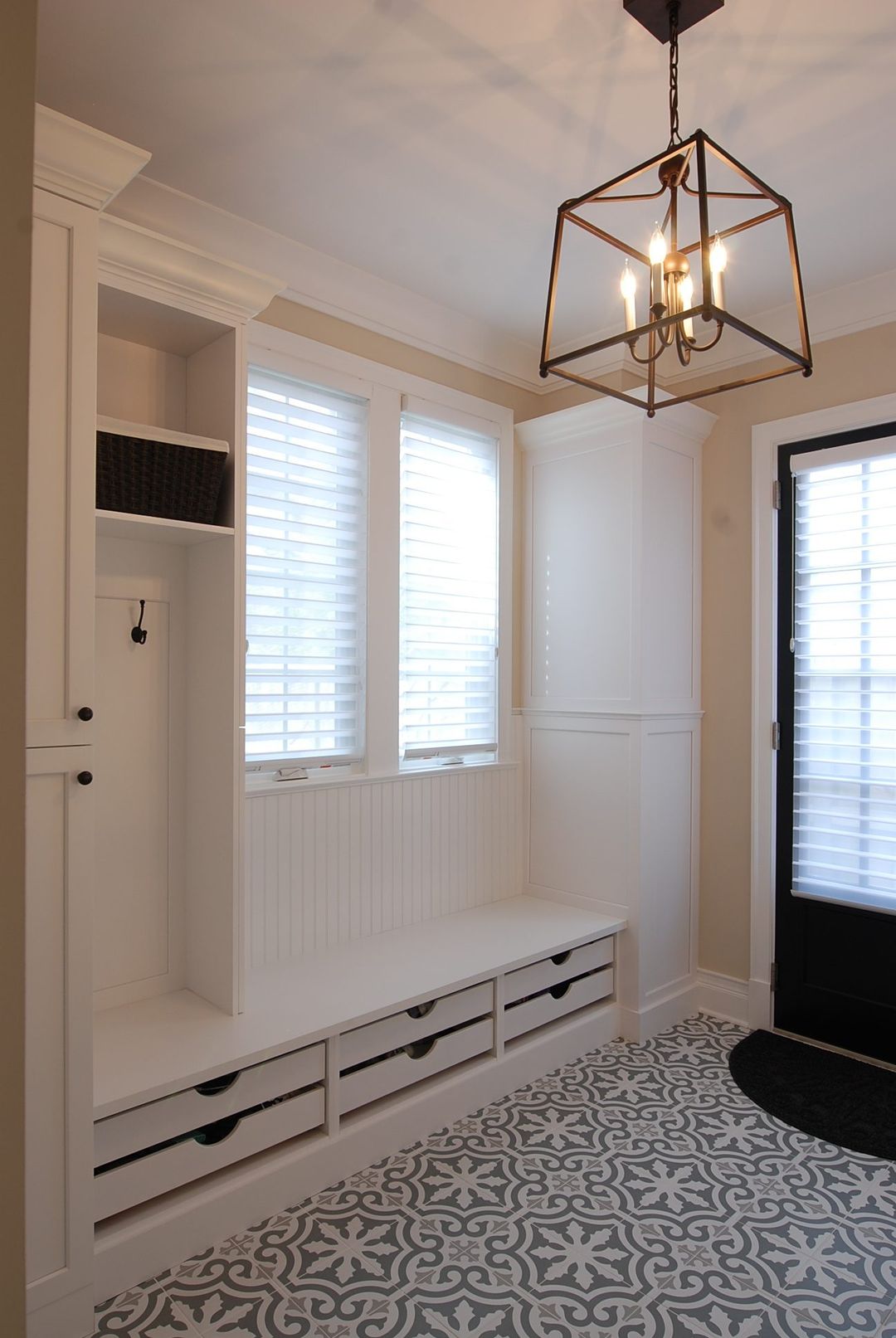 Winnetka mudroom with white built-in bench, under-seat shoe drawers, locker storage, and patterned tile floor - Kelly Thayer Design