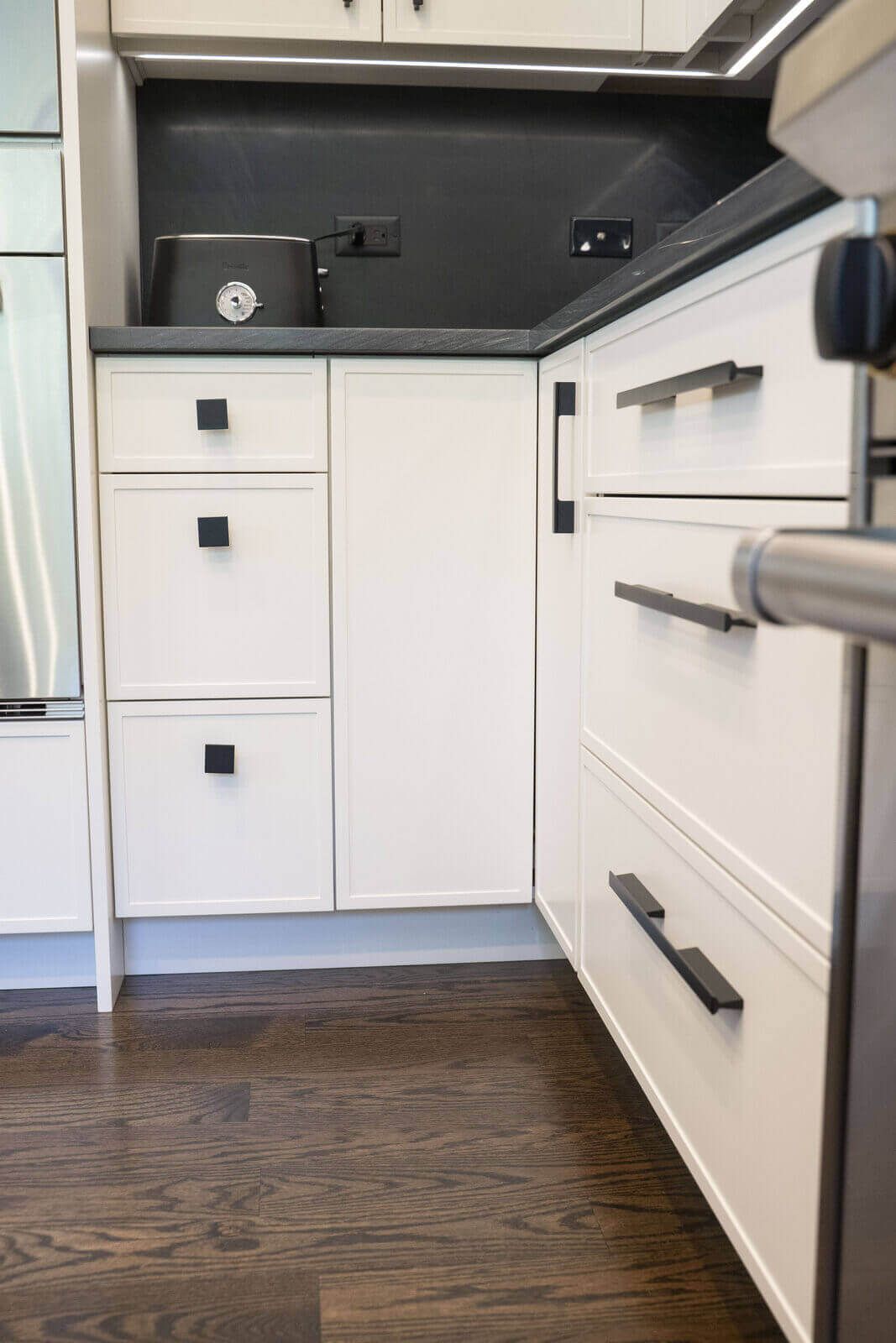 Northbrook Kitchen Remodel - Hidden Storage | Kelly Thayer Design Mixed-size matte black cabinet hardware with square knobs and bar pulls in Kildeer kitchen remodel