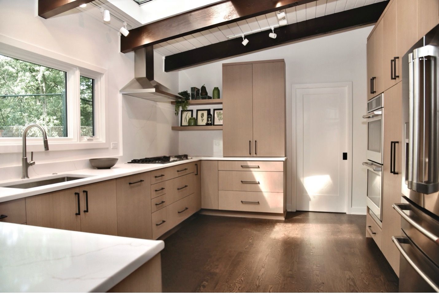 Riverwoods ranch kitchen remodel with vaulted wood-beam ceiling, light oak cabinetry, and wooded views by Kelly Thayer Design